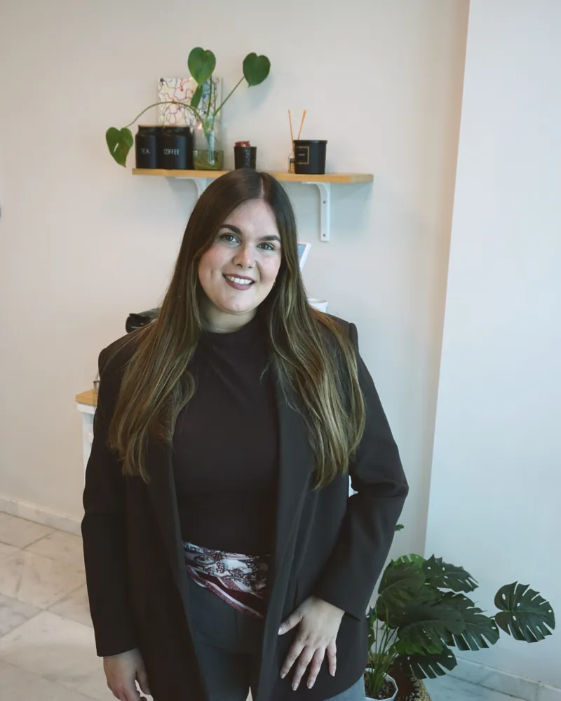 Alicia de pie en su consulta, sonriendo